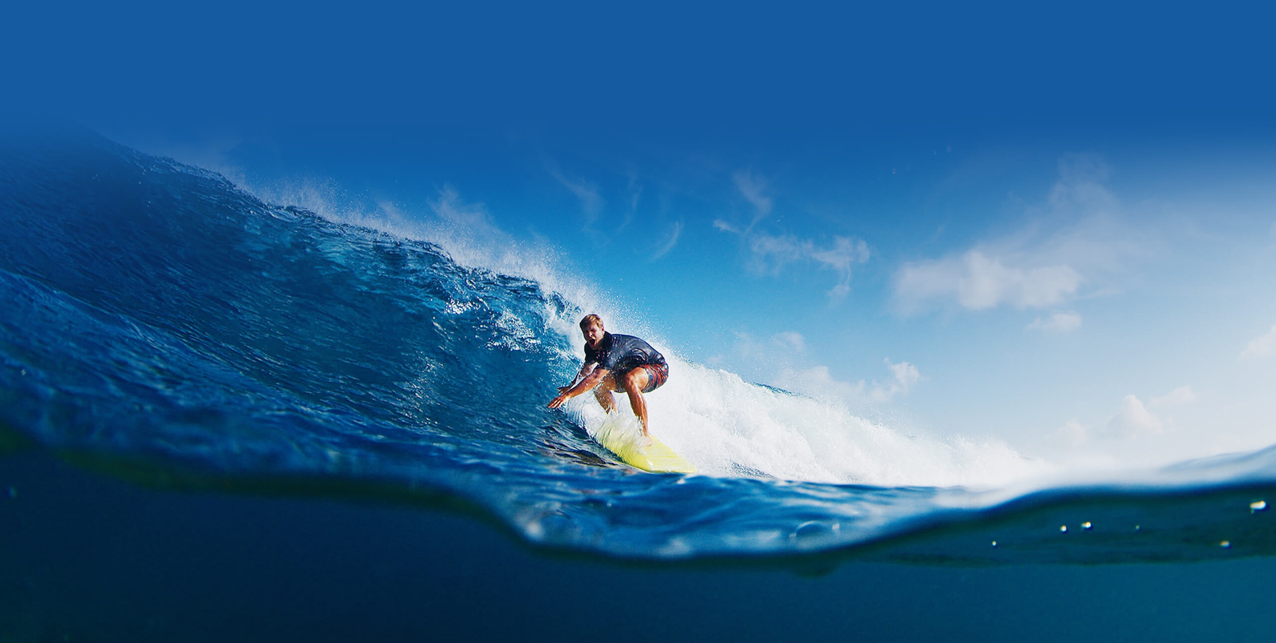 Tiki Surf School - Homme surfe une vague